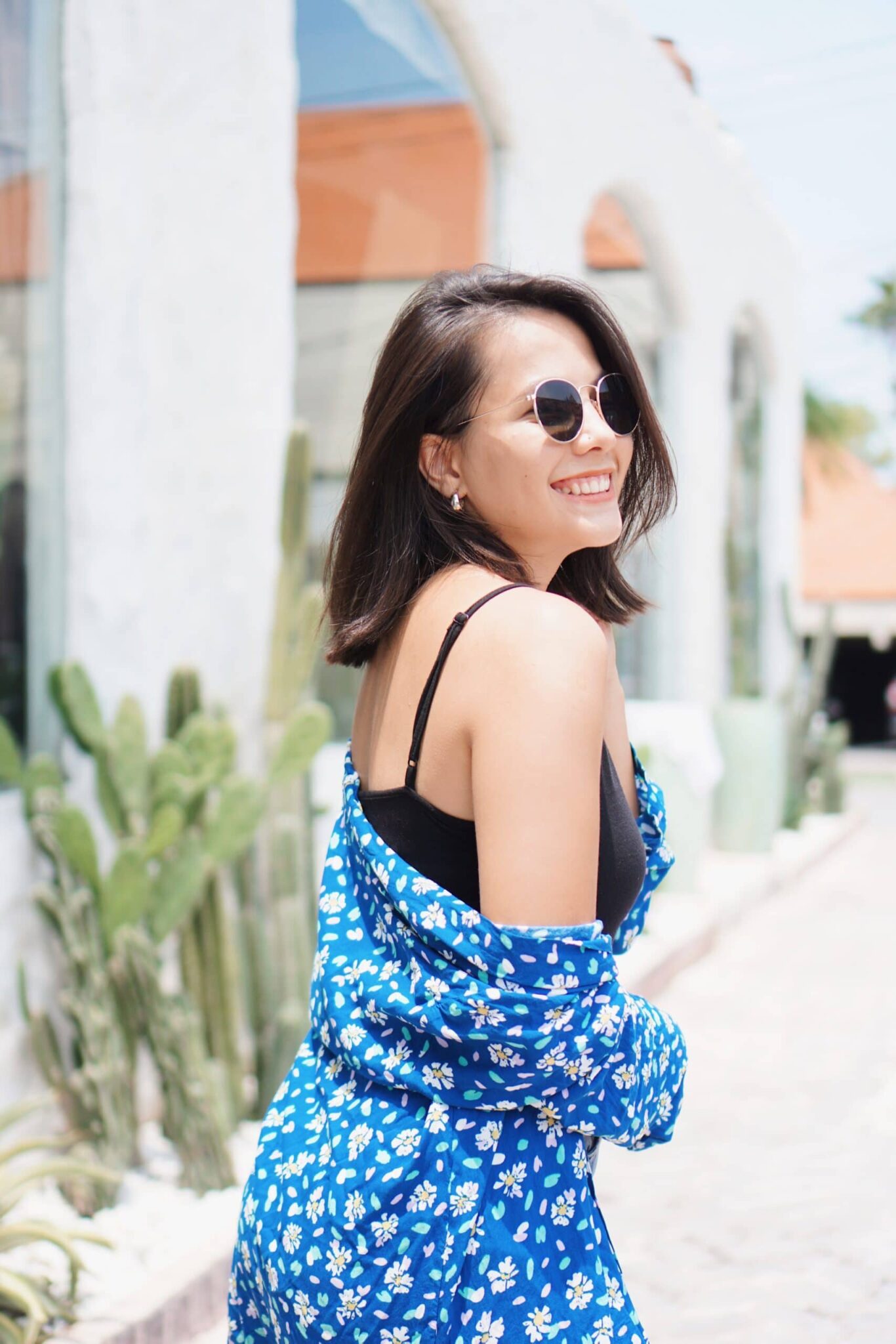 woman in blue and white floral spaghetti strap dress wearing black sunglasses